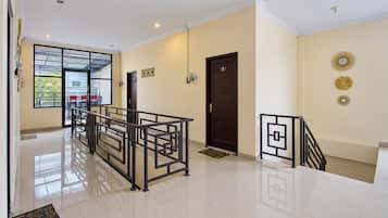 Eine Hotelhalle mit einer Rezeption, einer Treppe und einer Tür mit der Nummer 8.