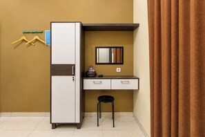 A compact room with a built-in wardrobe, a small desk with a mirror, and a stool. - Hotel O near Monumen Jogja Kembali (Ngaglik)