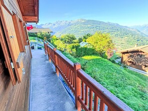 Un balcó de fusta amb vista a un paisatge de muntanya.