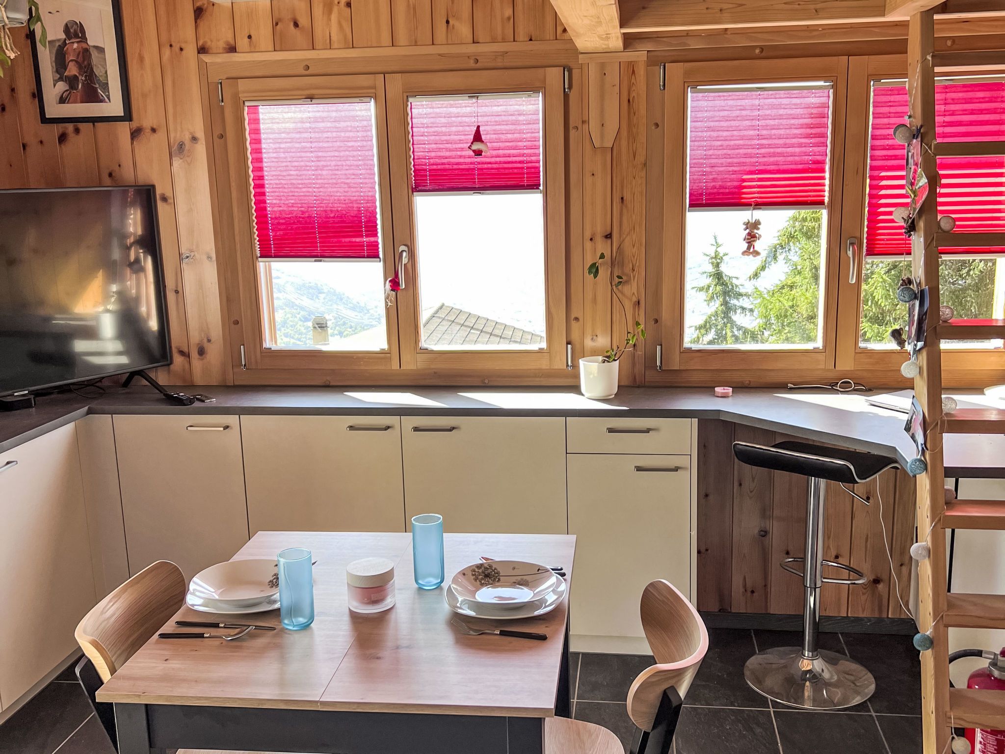 Puinen mökki, jonka sisätiloissa on keittiö, ruokapöytä ja baaritiski.