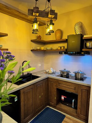 Cocina con armarios de madera, estufa integrada y lámparas colgantes.