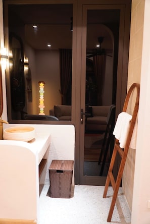 Un baño con bañera, espejo, toallero y una escalera de madera.