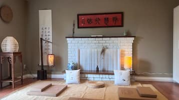 Ein Wohnzimmer mit Kamin aus weißem Backstein, einem traditionellen chinesischen Kalligraphie-Kunstwerk und einem roten Schild darüber.