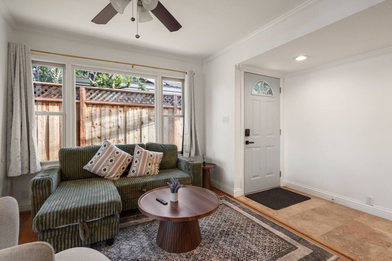 A room with a green sofa, a round table, and a door.