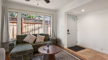 A room with a green sofa, a round table, and a door.