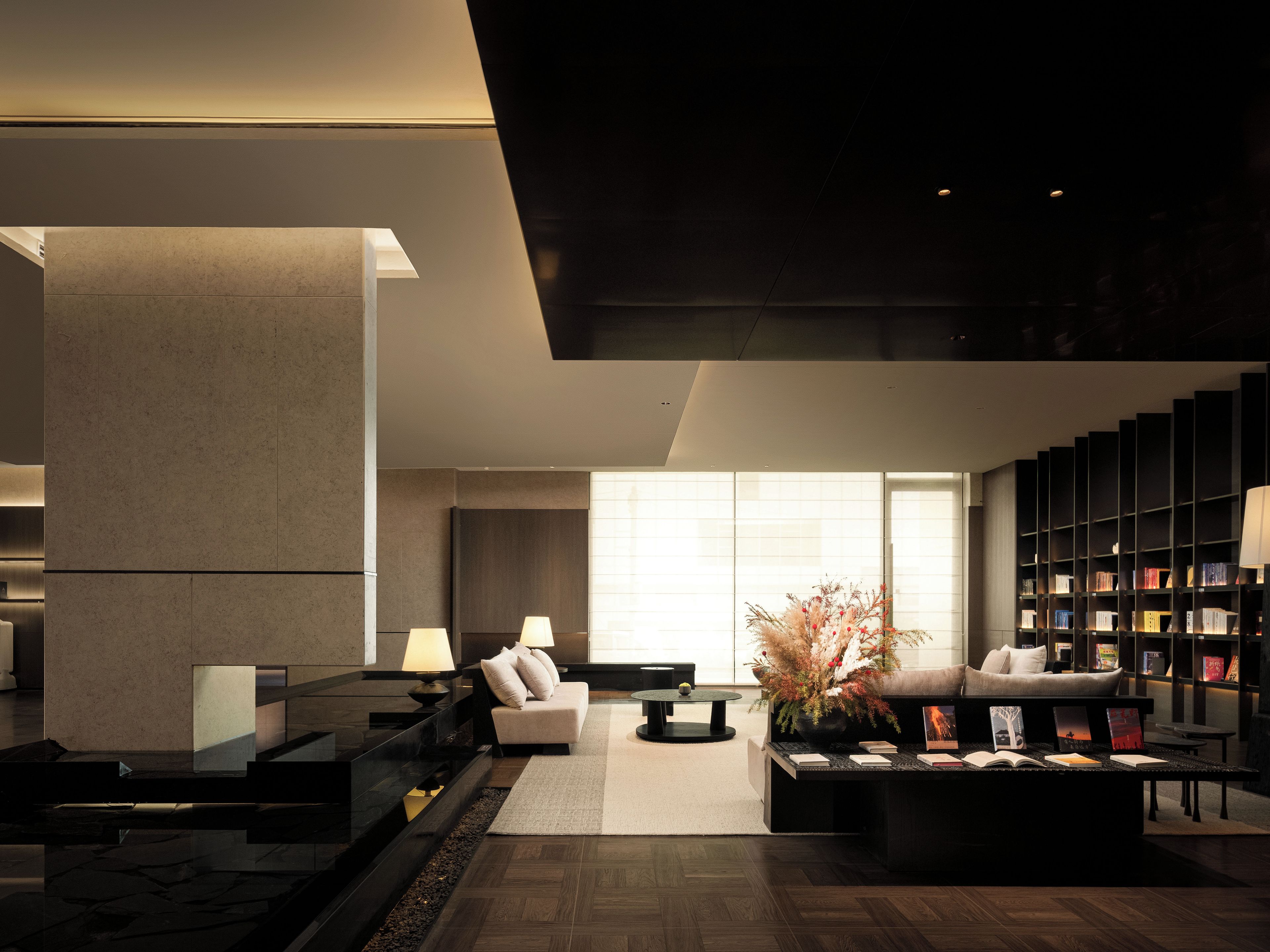 A modern living room with a fireplace, a sofa, a coffee table, and a bookshelf.