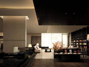 A modern living room with a fireplace, a sofa, a coffee table, and a bookshelf. - ShenyangStation West Square Atour Hotel (Shenyang)