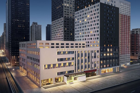 A modern hotel with a prominent entrance, multiple floors, and a view of surrounding high-rise buildings. - ShenyangStation West Square Atour Hotel (Shenyang)