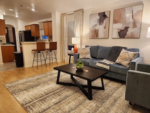 A modern living room with a sofa, coffee table, and a rug. - Fully Furnished East Austin Home - Workstation & WiFi - Near Downtown & Airport (Austin)