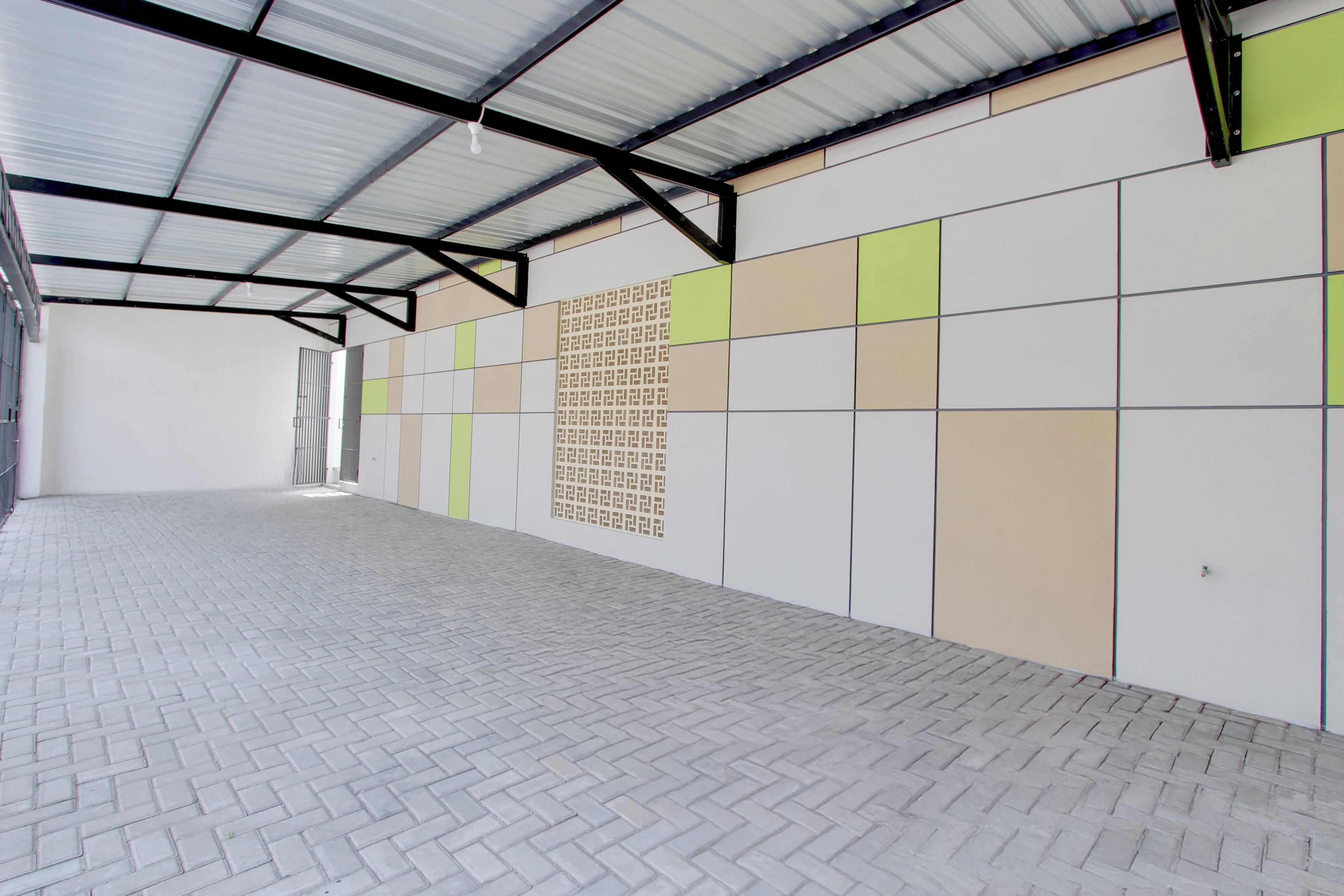 A spacious indoor area with a tiled floor and a wall with a geometric pattern.