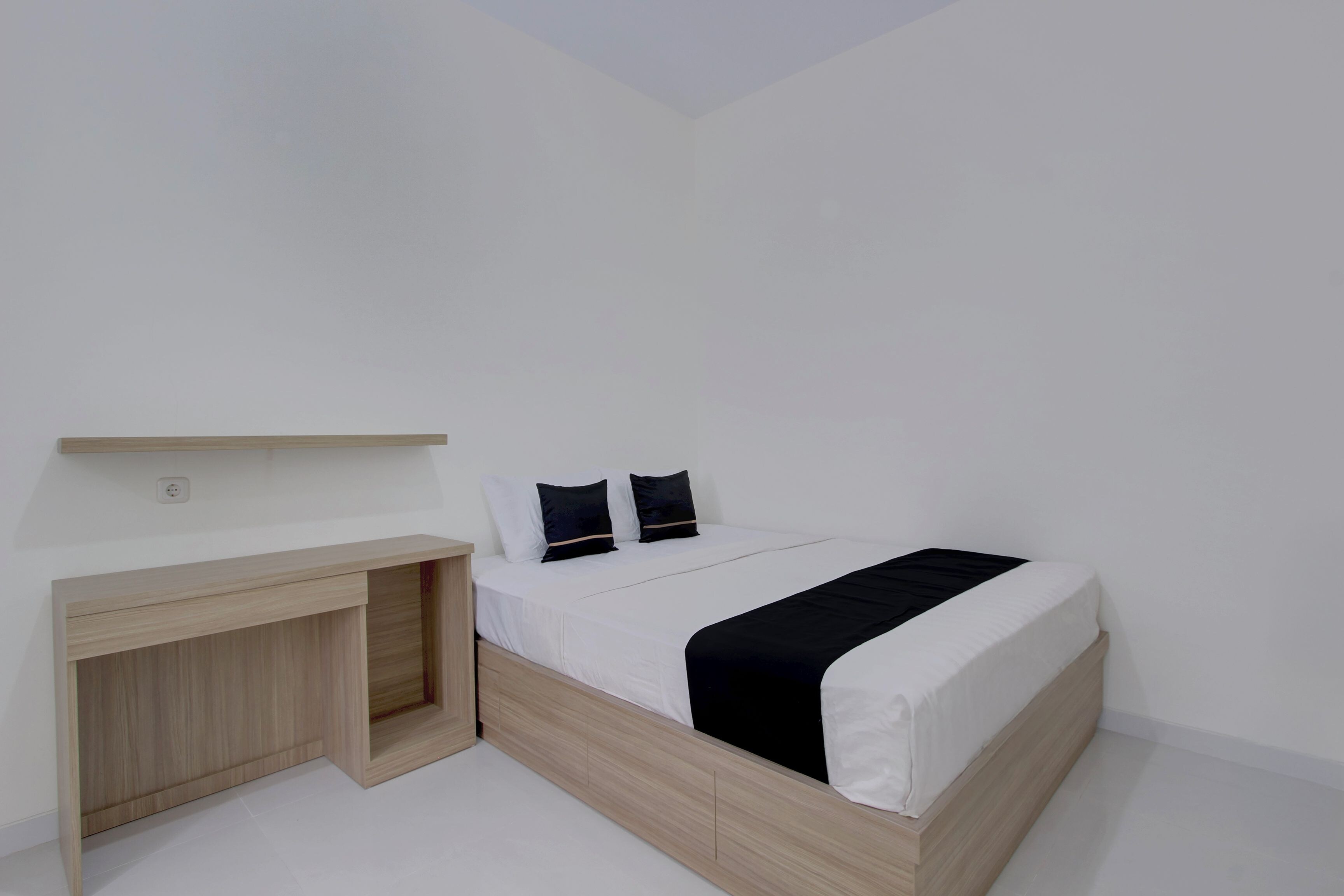 Un dormitorio con una cama, un escritorio y una estantería.