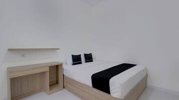 Un dormitorio con una cama, un escritorio y una estantería.