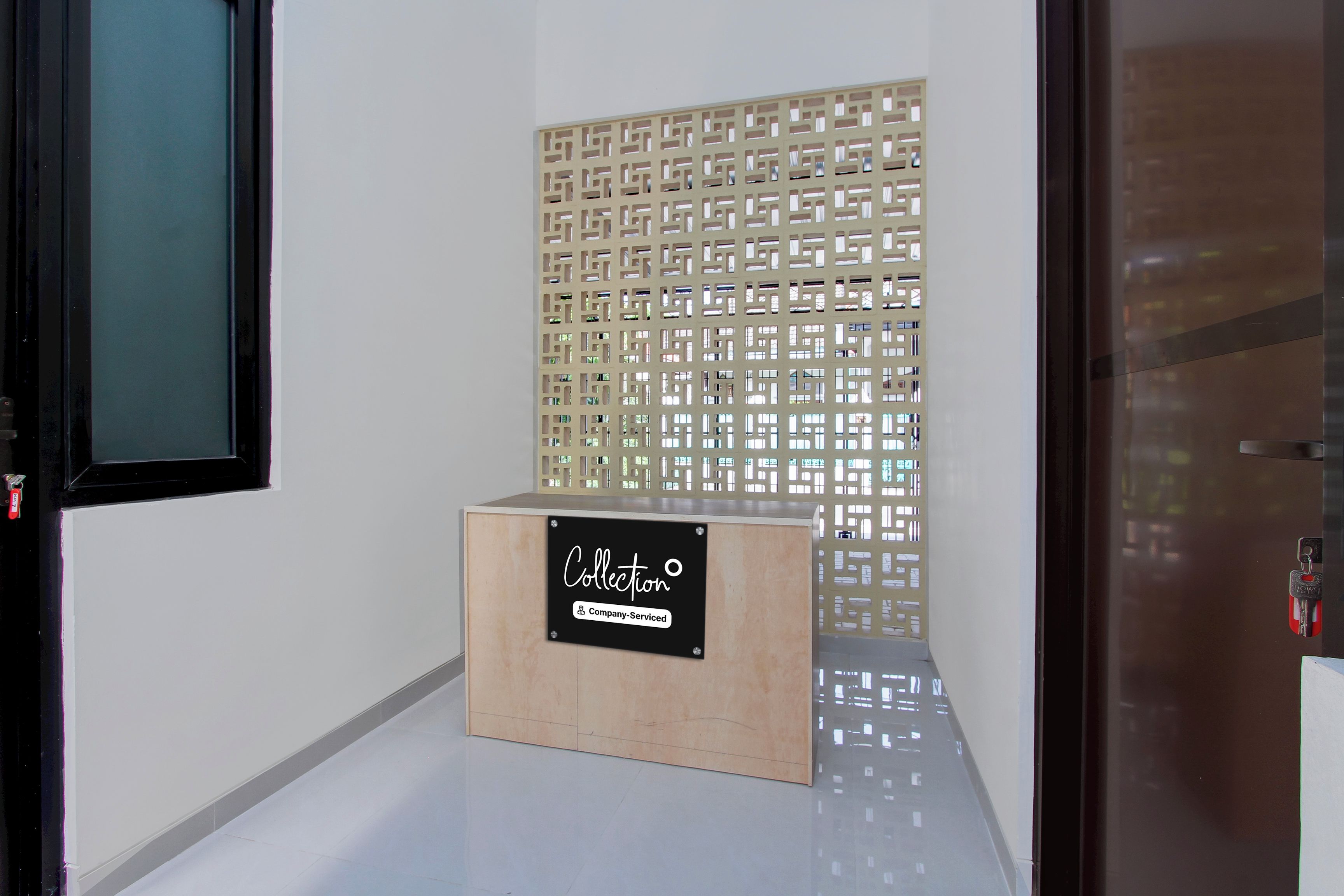 A reception area with a wooden reception desk labeled 'Collection' and a decorative panel with a geometric pattern.