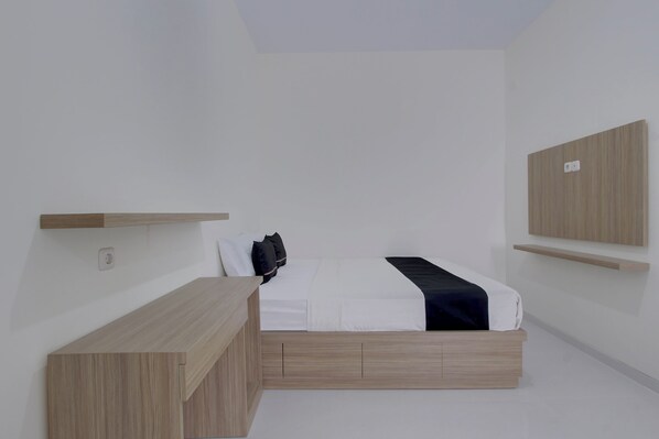 A minimalist bedroom with a bed, bedside tables, and built-in shelving.