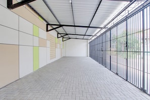 A spacious indoor area with a tiled floor and a metal-framed ceiling.