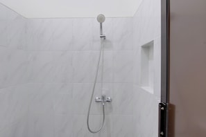 Ducha con cabezal de ducha de mano y grifo empotrado.