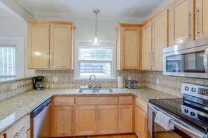 A kitchen with wooden cabinets, a built-in oven, a microwave, and a window above the sink. - 3BR + Gated Parking | Sleeps 8 /Mins to Broadway (Nashville)