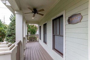 A covered porch with a ceiling fan, a wooden railing, and a house number sign. - 3BR + Gated Parking | Sleeps 8 /Mins to Broadway (Nashville)