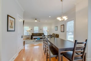 A spacious living room with a large dining table, a sofa, and a ceiling fan. - 3BR + Gated Parking | Sleeps 8 /Mins to Broadway (Nashville)