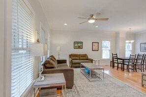Ein großzügiges Wohnzimmer mit einer Couch, einem Couchtisch und einem Essbereich mit Stühlen.