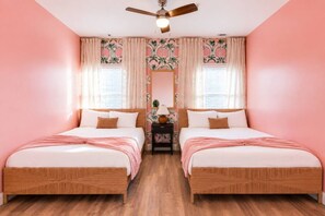 A room with two beds, a ceiling fan, and a nightstand with a lamp. - Nashville Double Take | 2 Stylish Stays | Sleep 12 (Nashville)