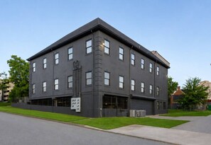 A multi-story building with a flat roof, large windows, and a signboard on the ground floor. - Chic+Cozy Nashville Duo | Sabrina & Cabin|Sleeps 8 (Nashville)