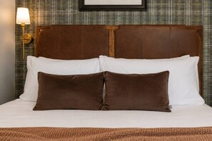 A bed with white and brown pillows, a brown headboard, and a plaid-patterned wall. - Chic+Cozy Nashville Duo | Sabrina & Cabin|Sleeps 8 (Nashville)