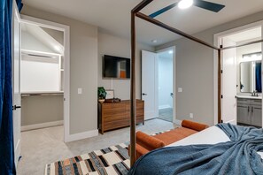 A bedroom with a four-poster bed, a television on the wall, a dresser, and a walk-in closet. - Nashville Stay Near Downtown | 3BR on Fern Ave (Nashville)