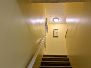 A staircase with wooden steps and a white handrail, leading to a landing with a framed picture on the wall. - 3-bedroom townhome in lovely Lithonia with cool AC (Lithonia)