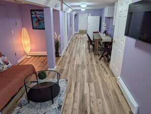 A hallway with a dining area, a bed, and a lamp. - NYC Minutes Away - Afordable Spacious Private Apartment. (West New York)