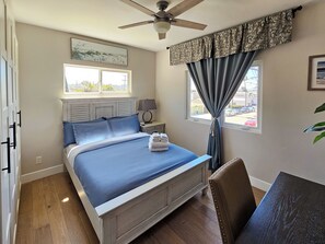 A bedroom with a bed, a desk, a chair, a ceiling fan, and a window with curtains. - Rooftop sunsets, central to all of San Diego (San Diego)