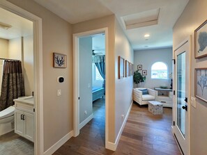A hallway leading to a bedroom with a bed, a small seating area, and a window with a view. - Rooftop sunsets, central to all of San Diego (San Diego)