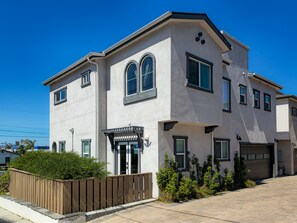 A two-story residential building with a garage, a covered entryway, and a landscaped front yard. - Rooftop sunsets, central to all of San Diego (San Diego)