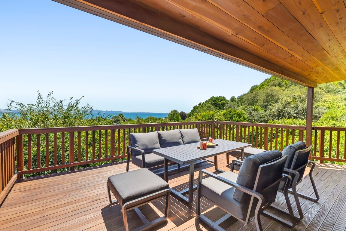 Terraza al aire libre con mesa y sillas, con vistas a un paisaje pintoresco.