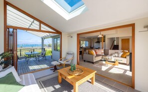 A spacious living area with a view of the sea, a dining area, and a kitchen.