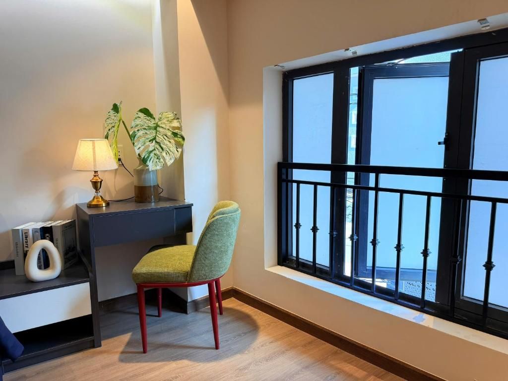 Une pièce comprenant un bureau, une chaise, une lampe et une grande fenêtre donnant sur un beau paysage.