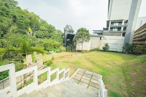 Un edificio de varios niveles con una escalera que conduce a un jardín en la azotea.