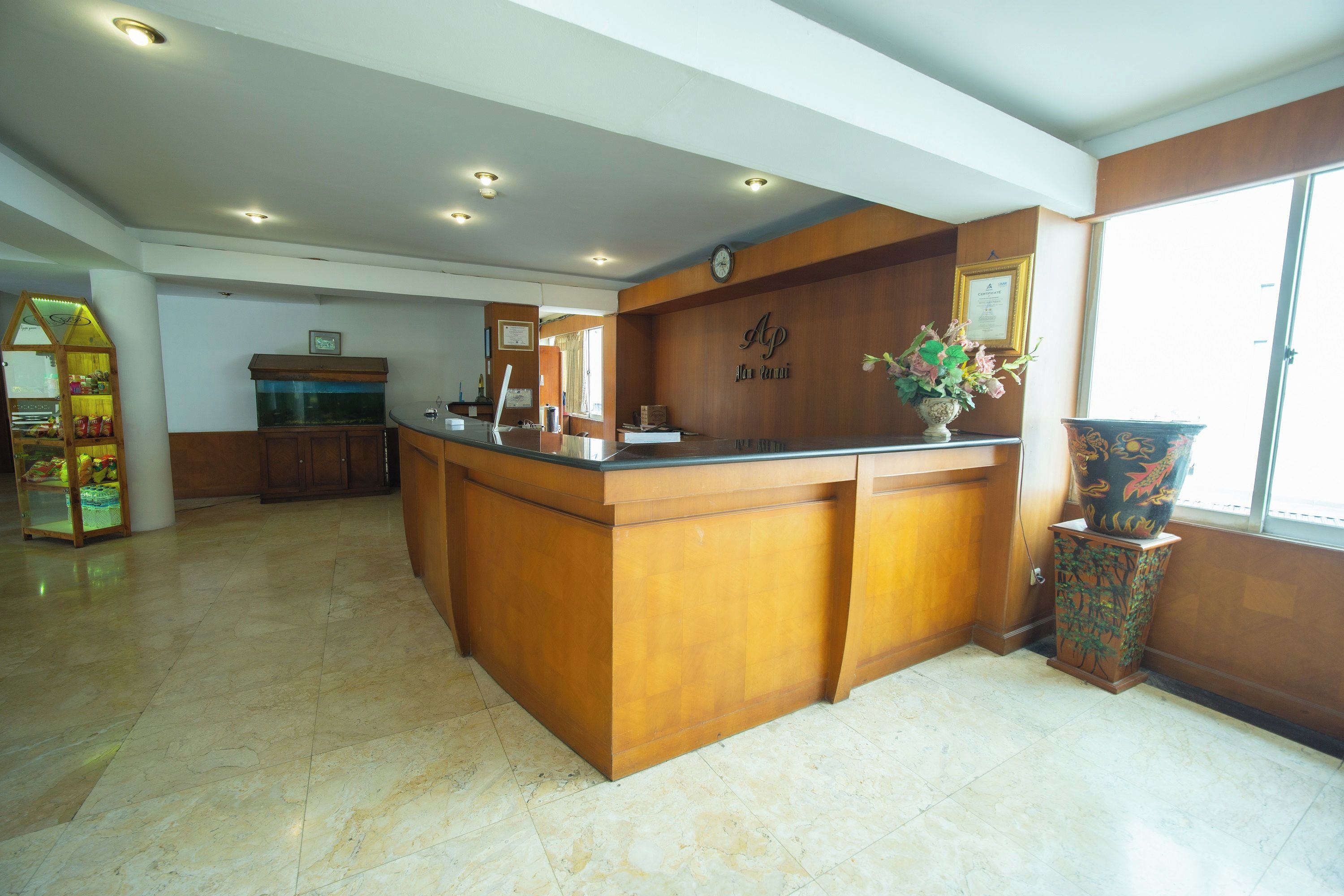 A reception area with a wooden reception desk, a clock on the wall, and a large window.