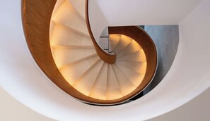 Eine Wendeltreppe mit Holzgeländer und beleuchteten Stufen.