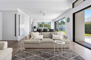 Uma sala de estar moderna com um sofá, uma mesa de centro e um tapete.