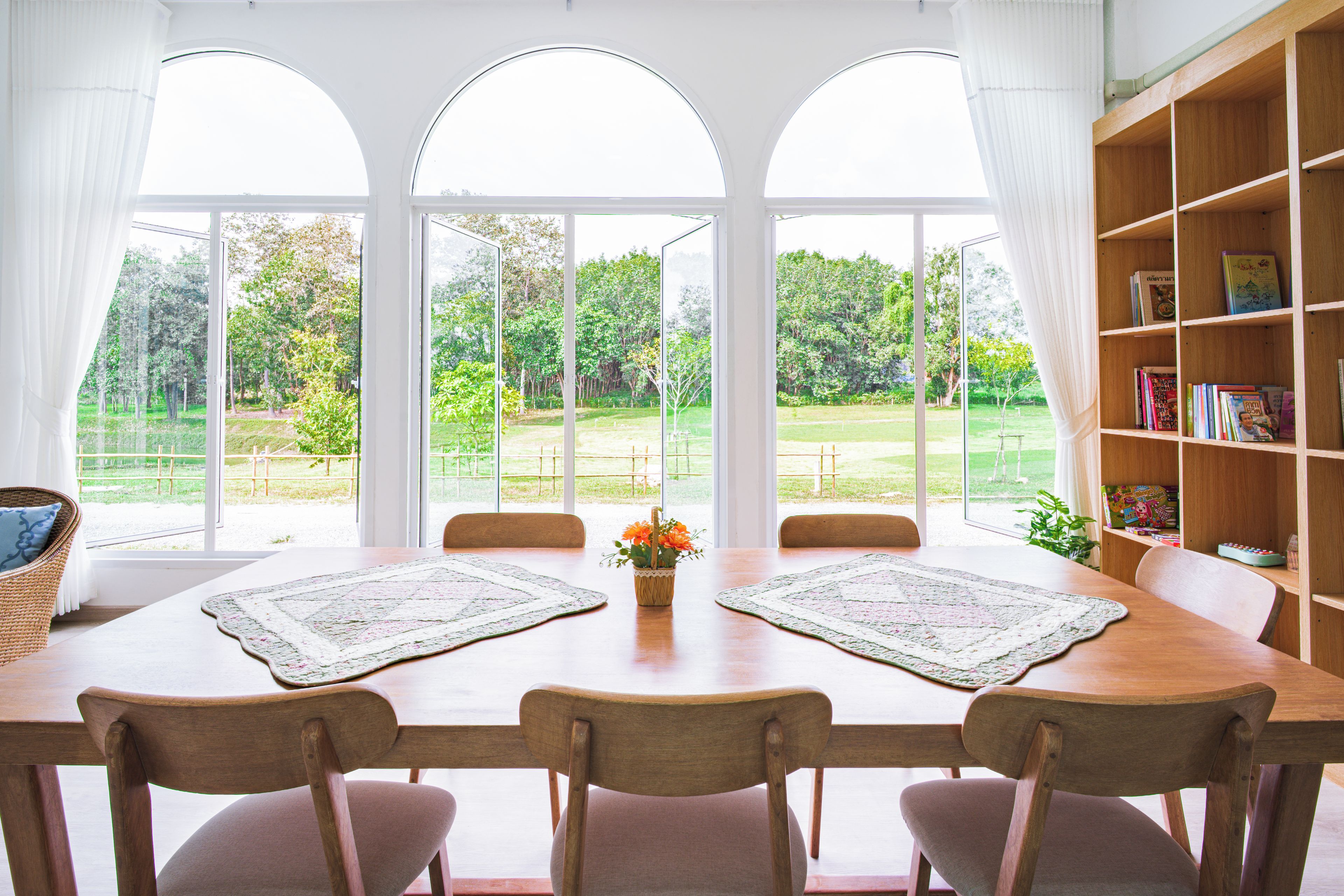 A dining area with a table, chairs, and a bookshelf.