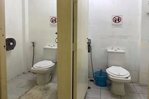 A restroom with two toilets, each with a sign prohibiting flushing sanitary waste. - The House Hostel 2  (Bangkok)