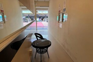 A corridor with a glass partition, a chair, and a table. - The House Hostel 2  (Bangkok)