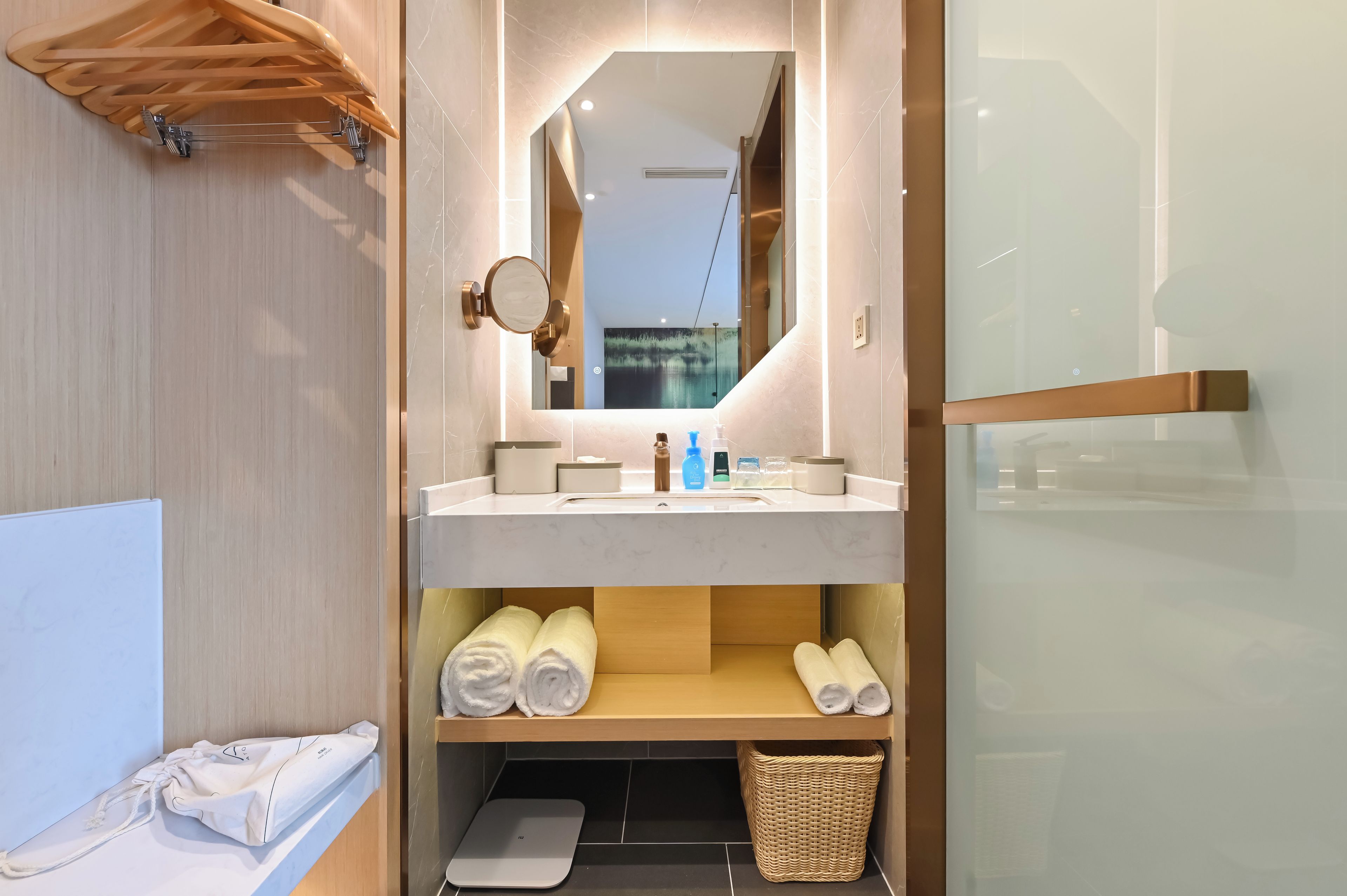 Une salle de bain moderne avec un meuble-lavabo en bois, un miroir, un porte-serviettes et un petit panier.