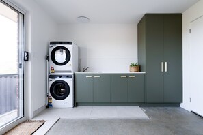 Ein kleiner Waschbereich mit Waschmaschine und Schrank.