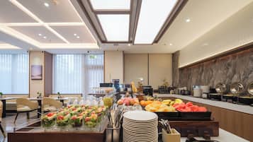 A buffet setup with various food items and utensils.