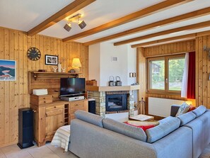 Una sala de estar acogedora con chimenea, televisor y decoración de madera.