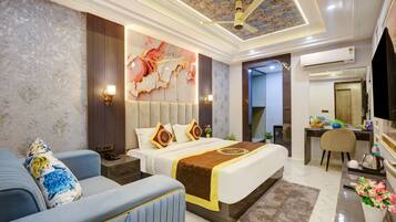 Una habitación de hotel con cama, zona de estar, escritorio y baño.