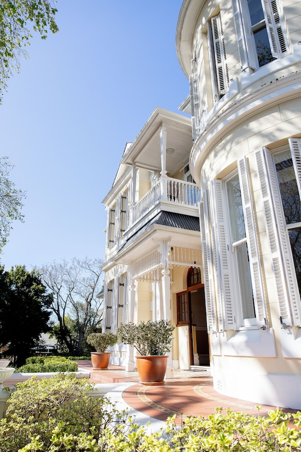 A two-story building with a balcony and a covered entrance.