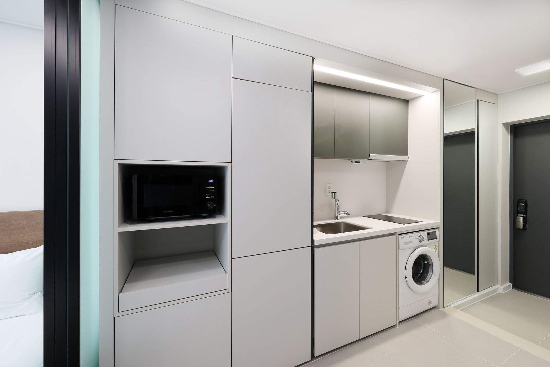 Una cocina moderna con electrodomésticos integrados, un lavamanos y una lavadora.